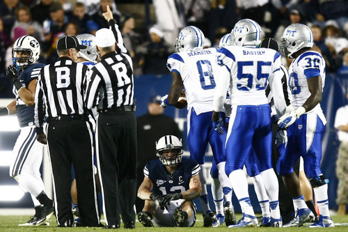 Chris Detrick  |  The Salt Lake Tribune
Brigham Young Cougars wide receiver JD Falslev (12) remains on the ground after Middle Tennessee Blue Raiders cornerback Sammy Seamster (8) recovered a fumble during the first half of the game at LaVell Edwards Stadium Friday September 27, 2013. BYU is winning the game 23-10 at halftime.